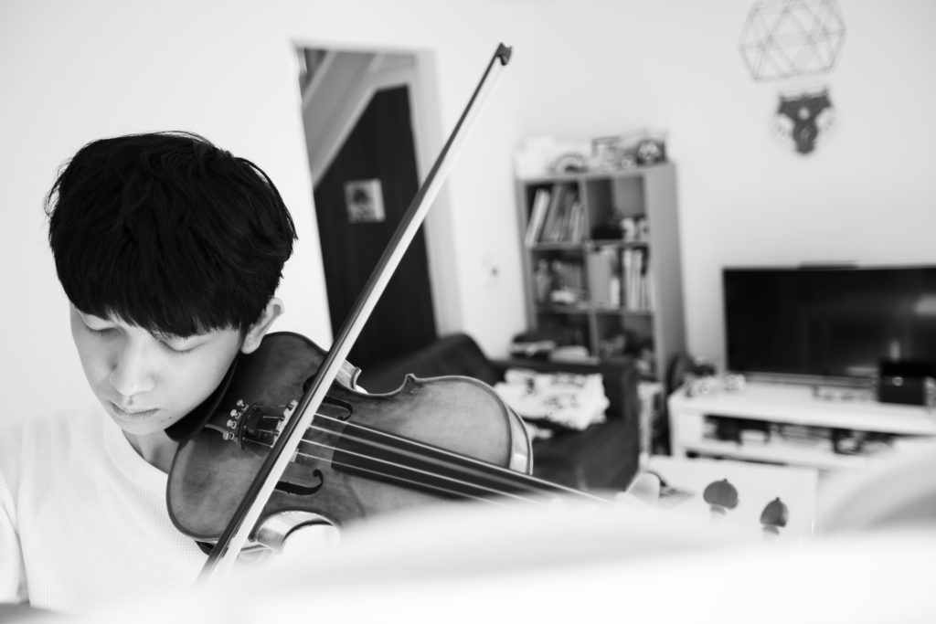 Young person in the foreground playing violin