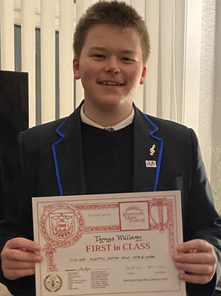 Young man in a blazer, holding a first in class certificate