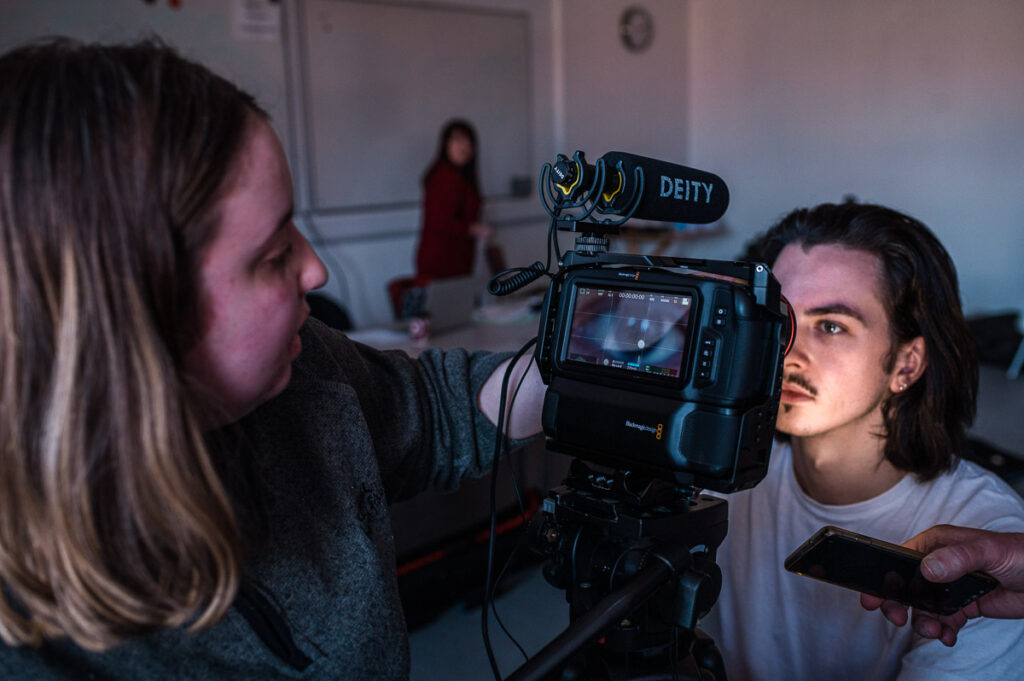 Two people playing with a filming camera, focusing on an eye