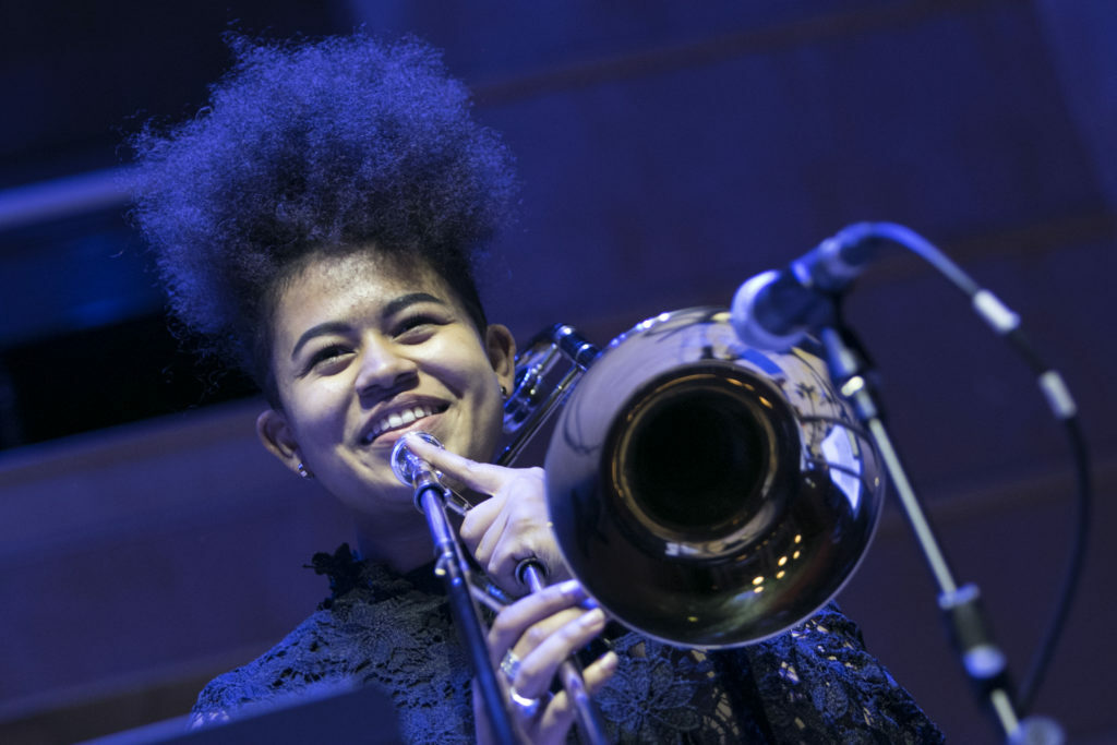 Young woman playing the trombone on stage