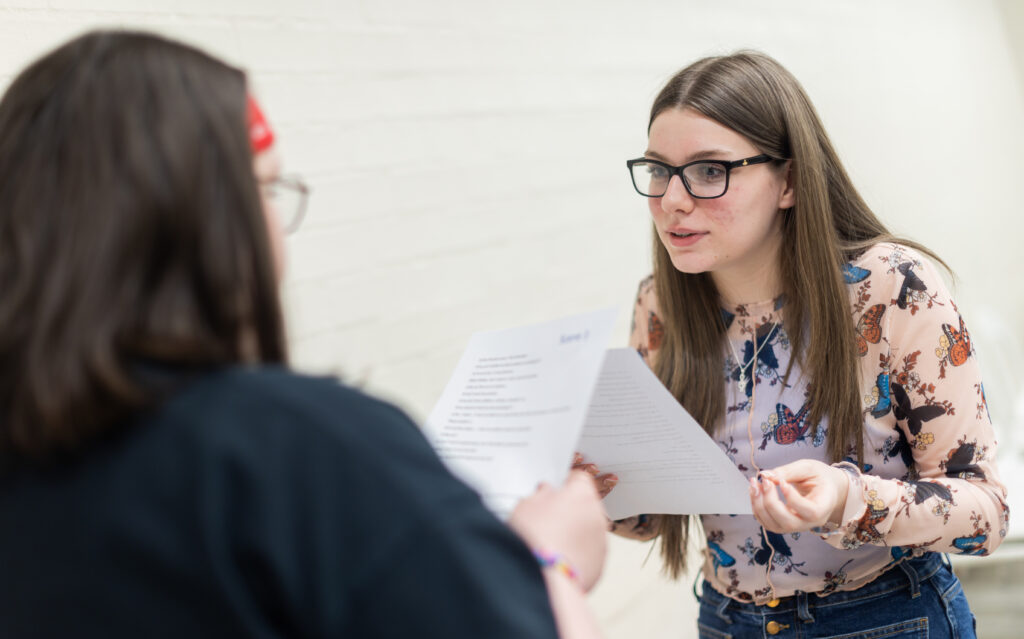 Two young people practising lines for acting