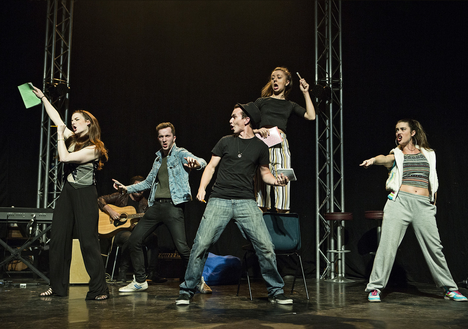 A group of performers on stage singing and moving