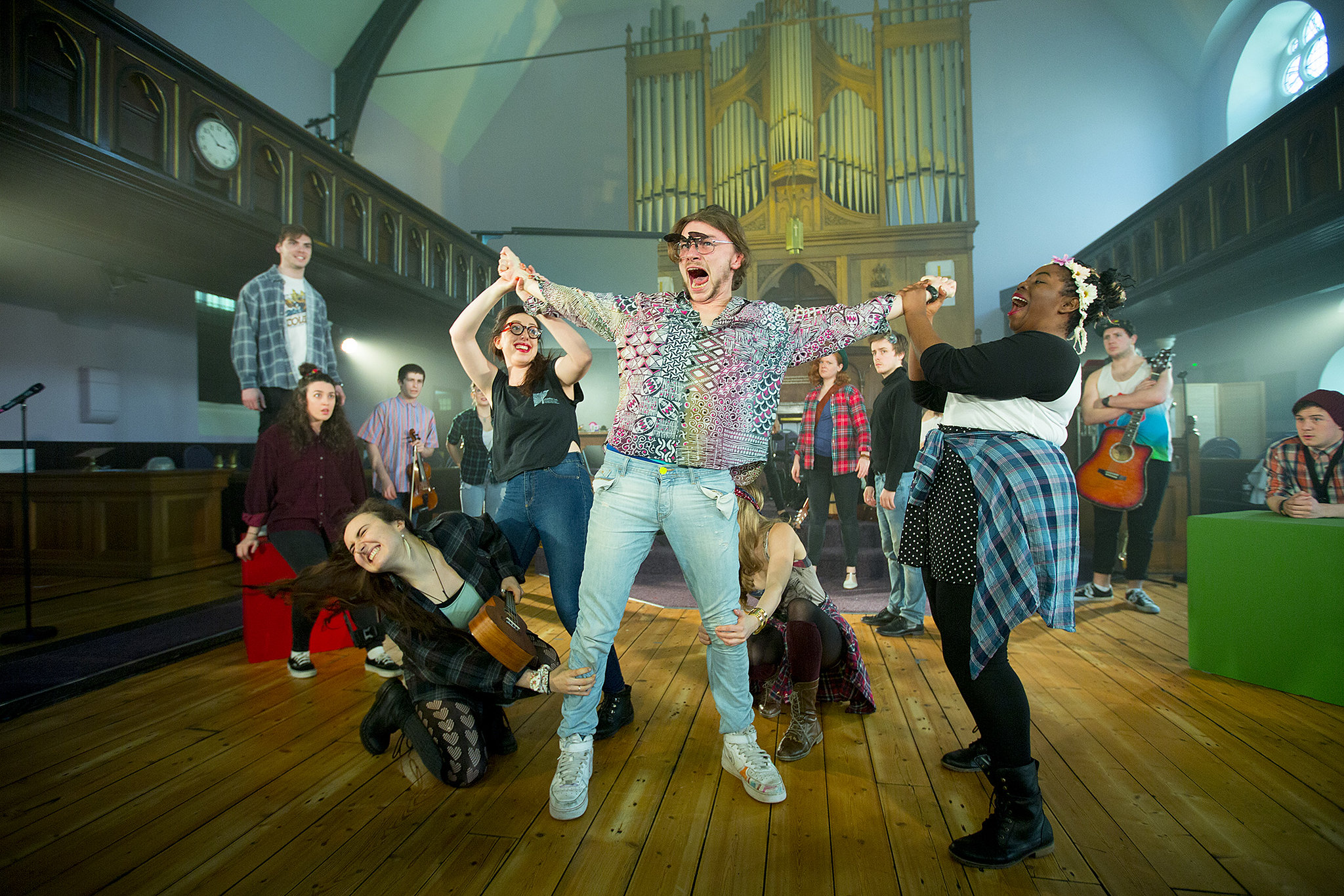 Group of musical theatre performers singing in a church hall