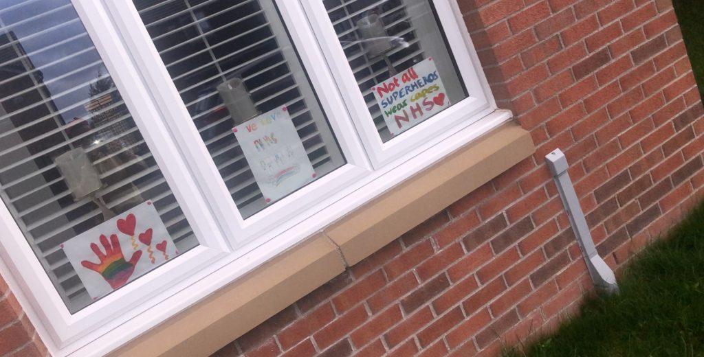Brick house with handwritten signs in the window