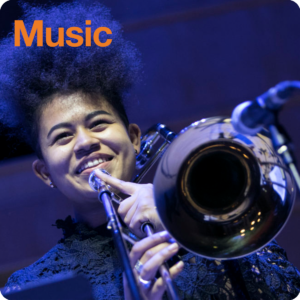 Young person smiling while holding a trombone